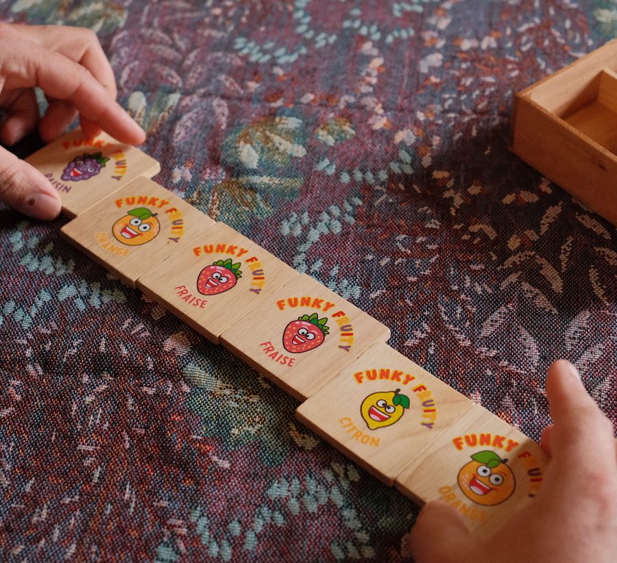 Réglette du jeu Funky Fruity en bois, tuiles fruits alignées sur la table
