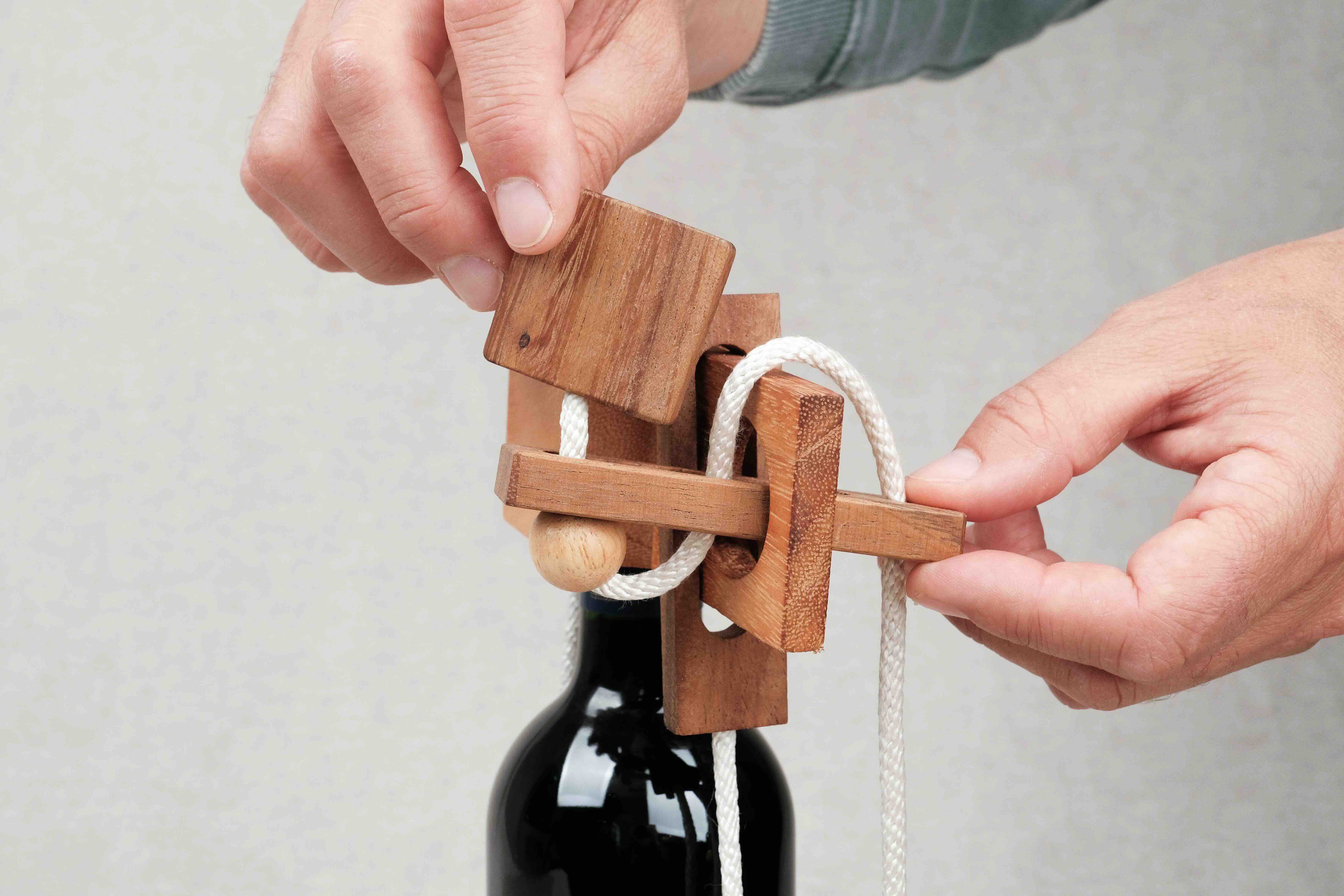 mains manipulant le casse-tête bouteille de vin en bois – Jeux Faugère