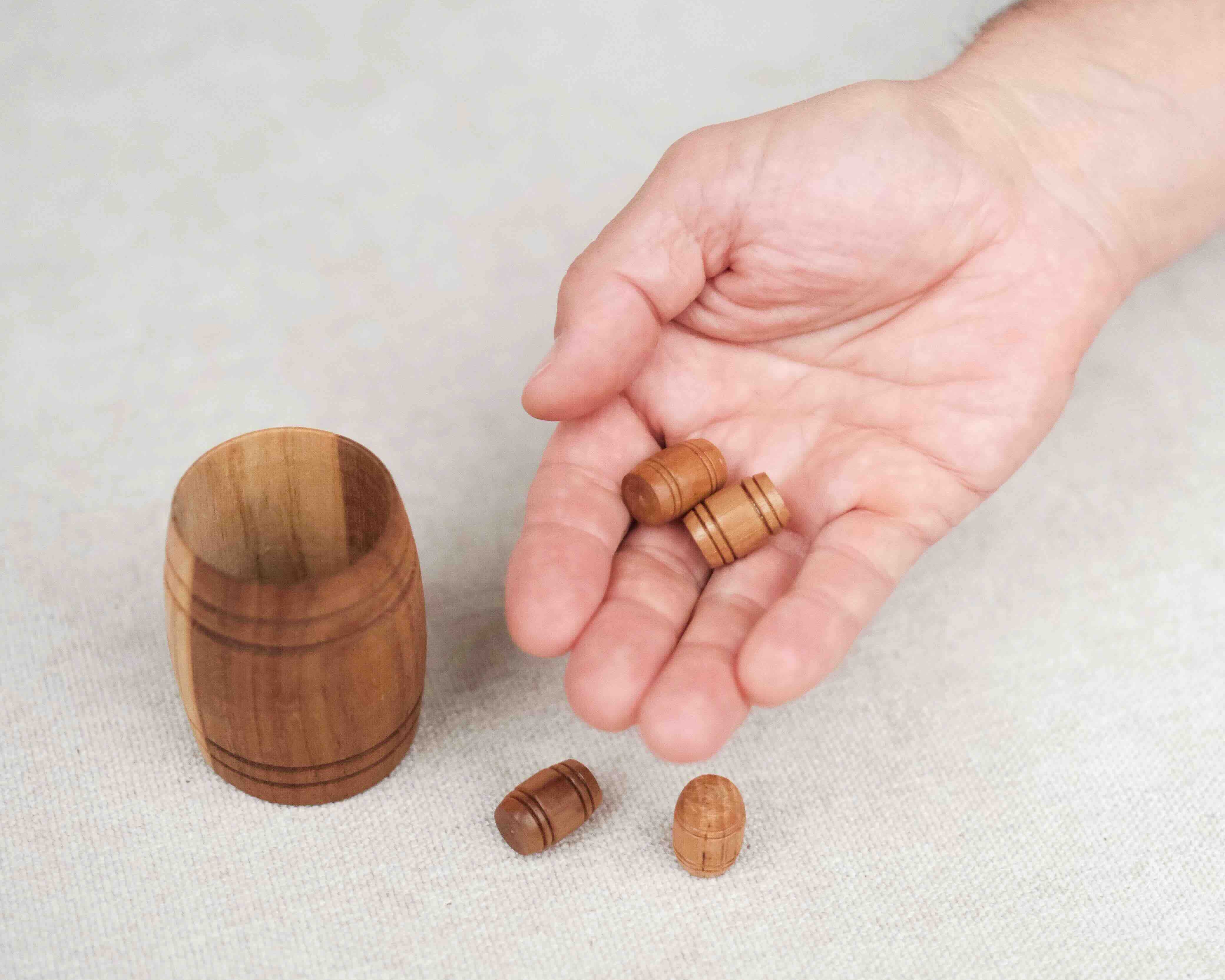 Démonstration du des pions tonneaux du jeu d’adresse avec le Tonneau de Bacchus en bois.