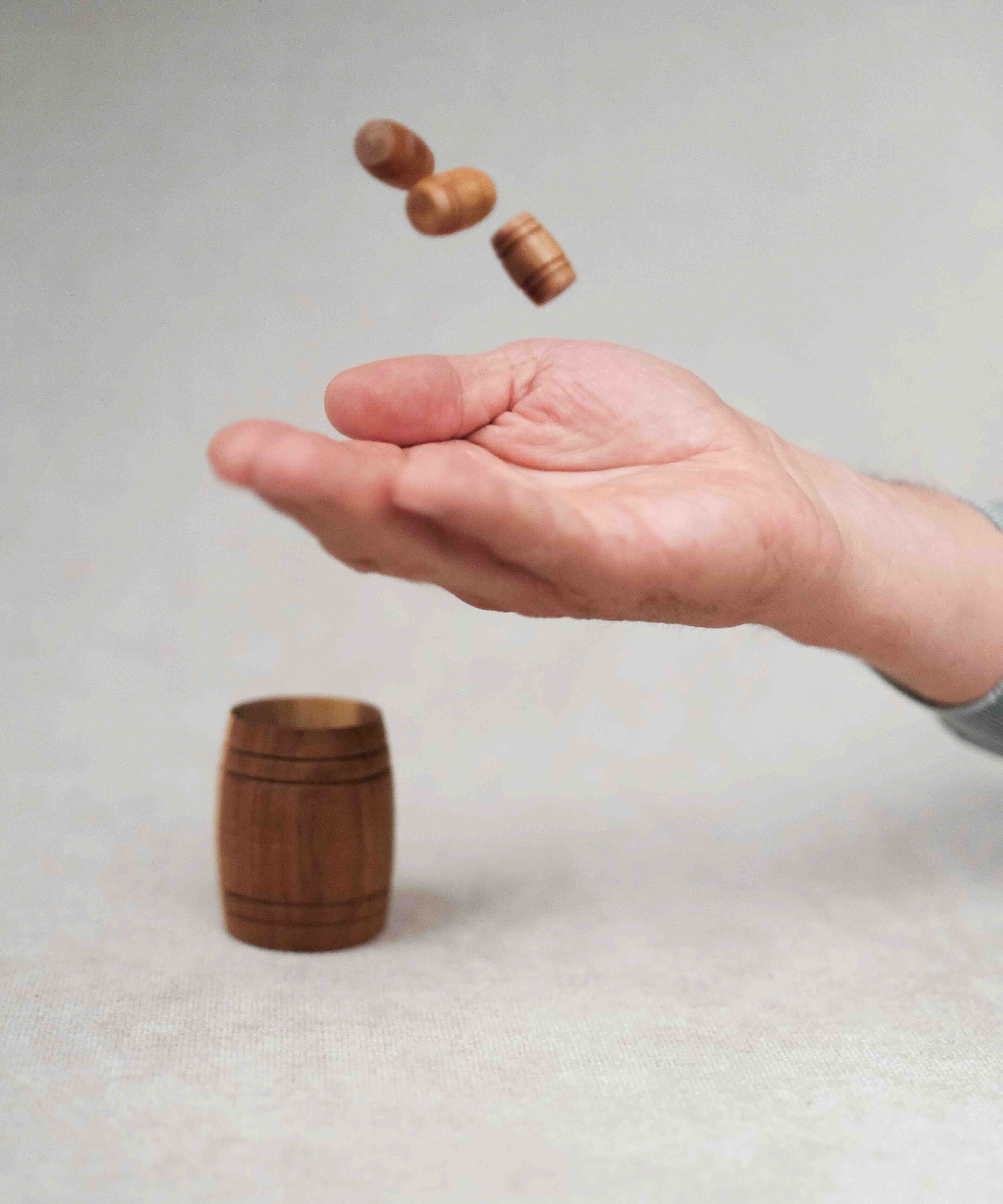 Main lançant les petits tonneaux dans le grand Tonneau de Bacchus.