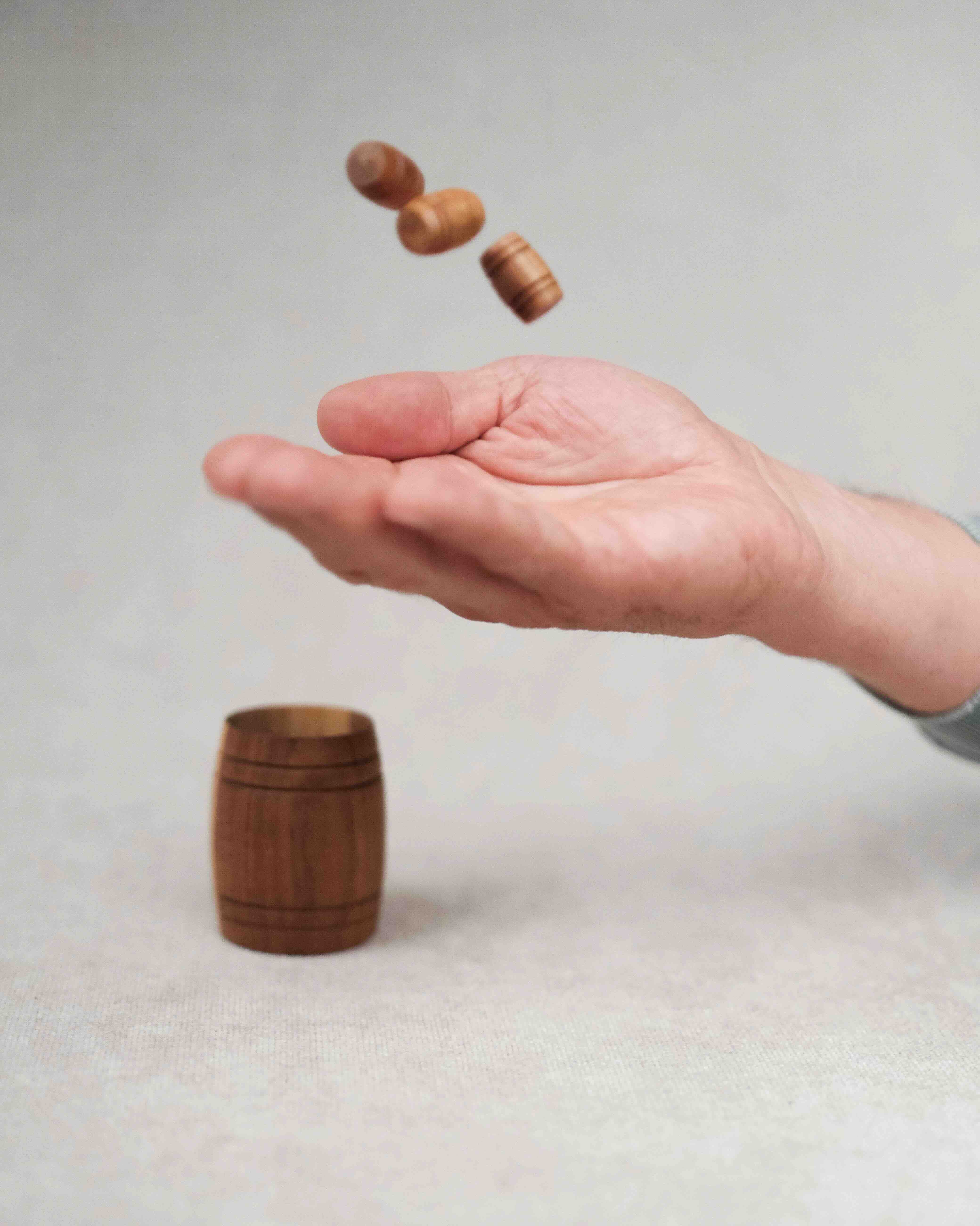 Main lançant les petits tonneaux dans le grand Tonneau de Bacchus.