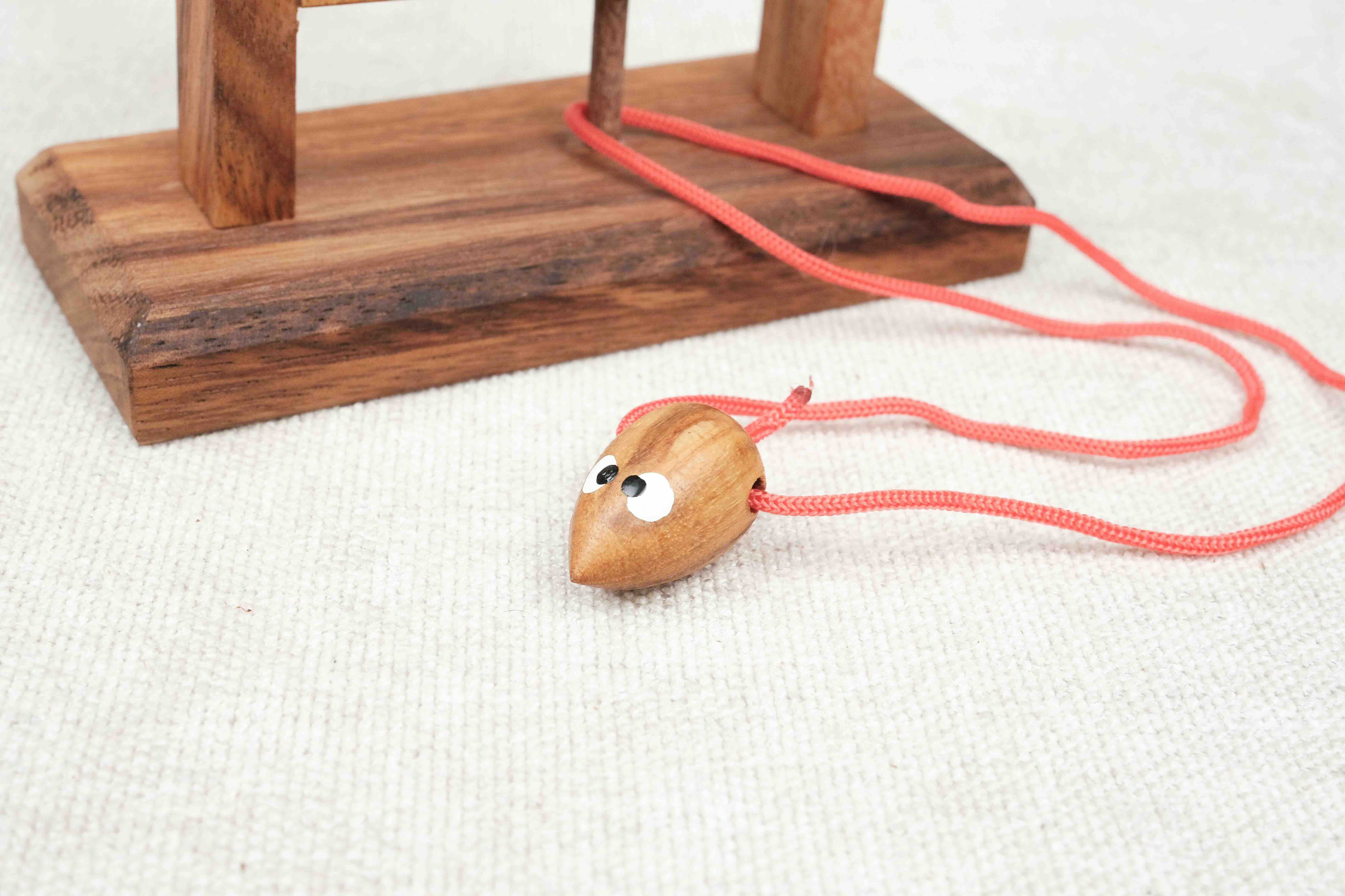 Gros plan sur la souris en bois avec ficelle rouge du casse-tête – Jeux Faugère