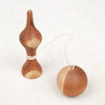 Bilboquet et boule posés côte à côte sur une surface beige