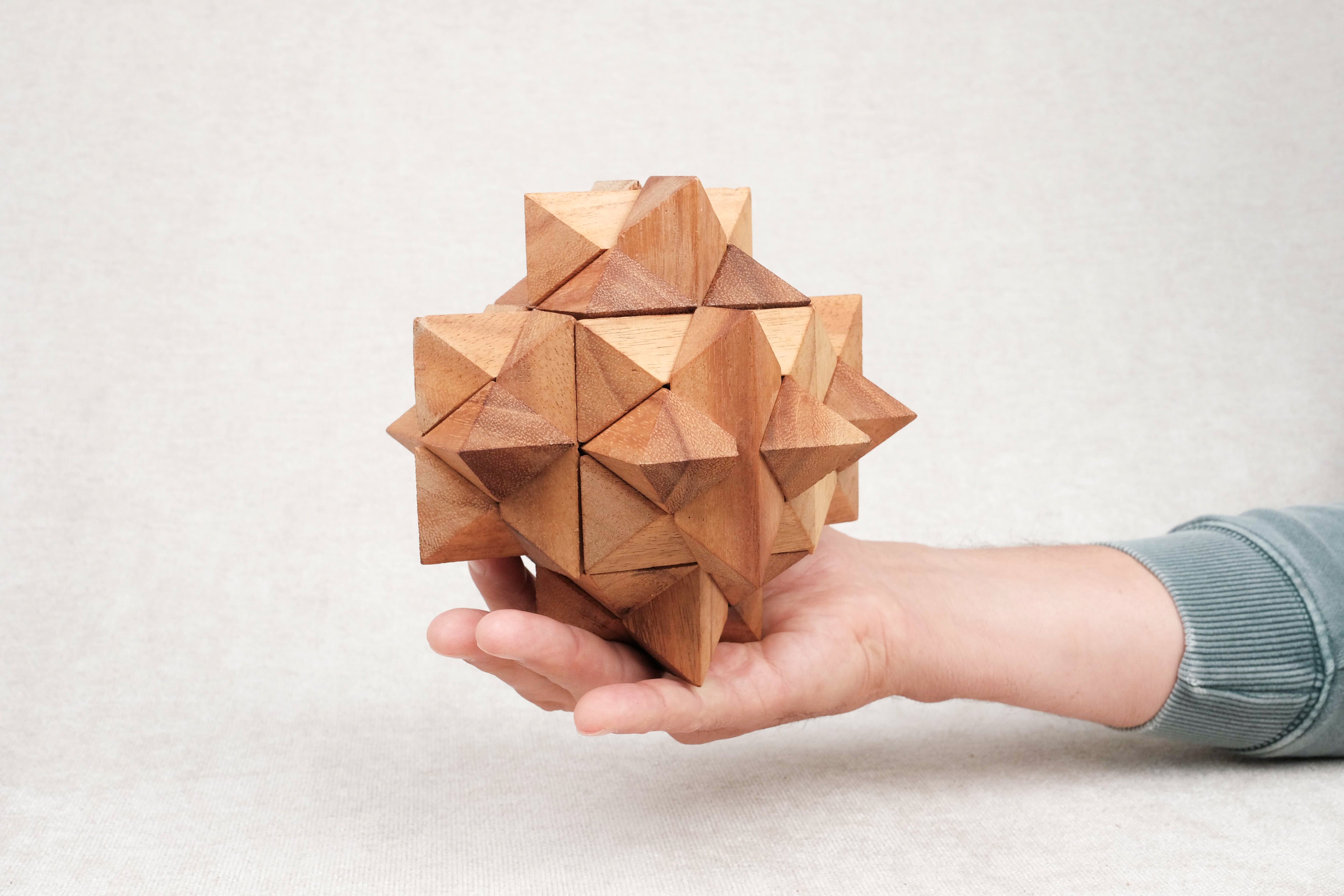 Casse-tête Antivirus L en bois tenu dans une main.