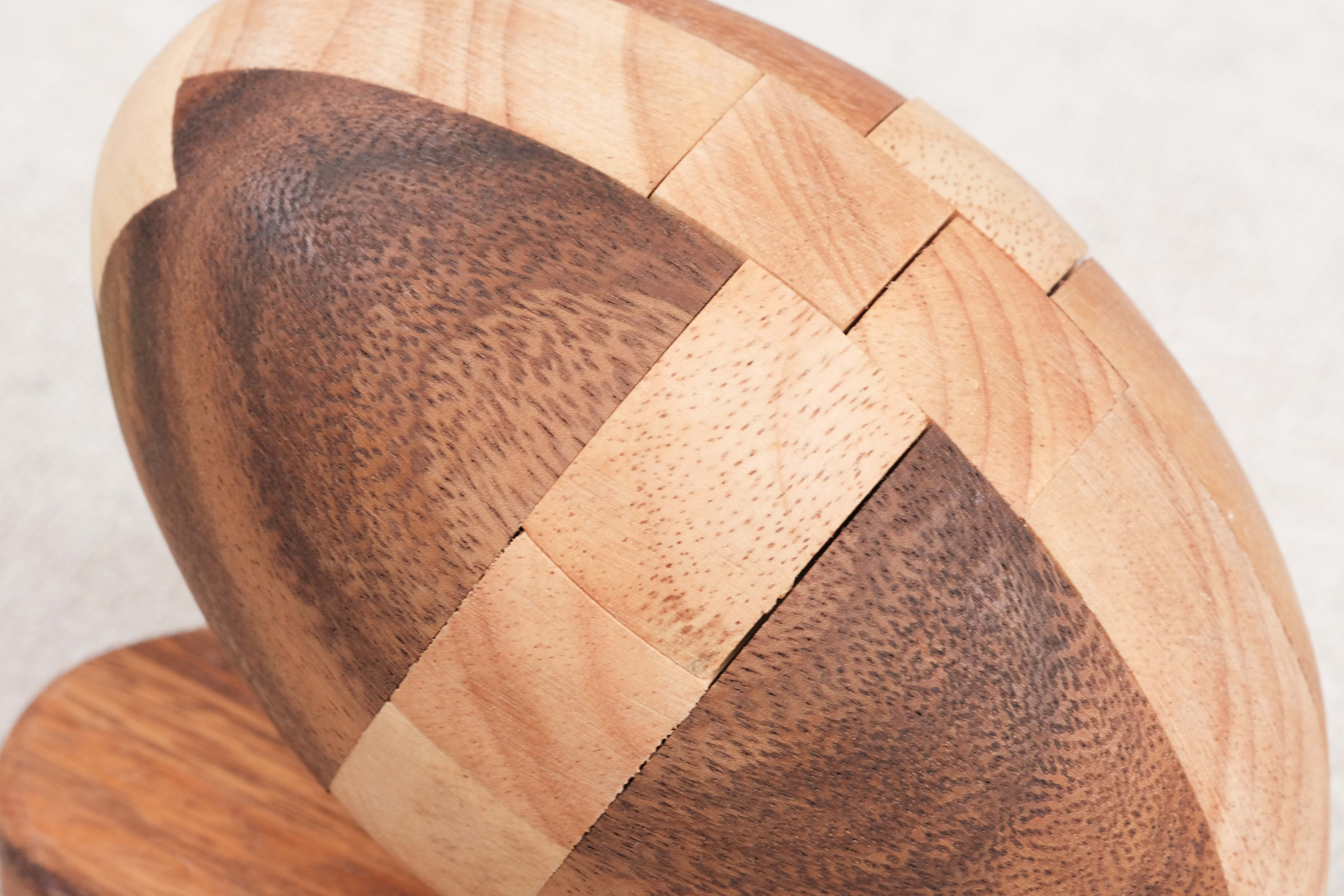 Zoom texture : Gros plan sur le Ballon de Rugby en bois avec détails des pièces ajustées.