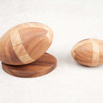 Comparatif tailles : Deux casse-têtes Ballon de Rugby en bois côte à côte, modèles M et L.