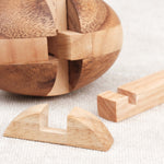 Vue pièces démontées : Pièces en bois du puzzle Ballon de Rugby prêtes à être réassemblées.