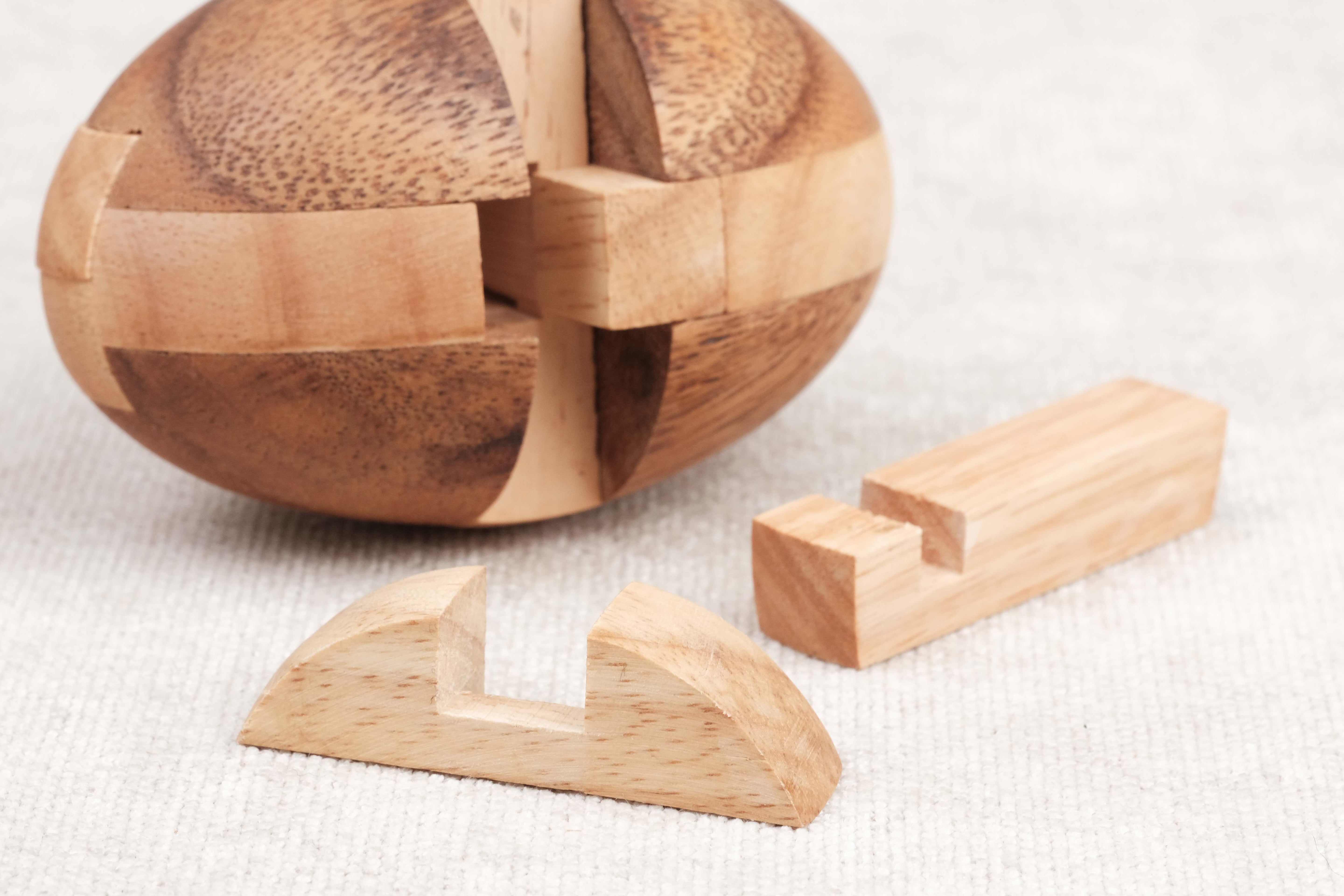 Vue pièces démontées : Pièces en bois du puzzle Ballon de Rugby prêtes à être réassemblées.