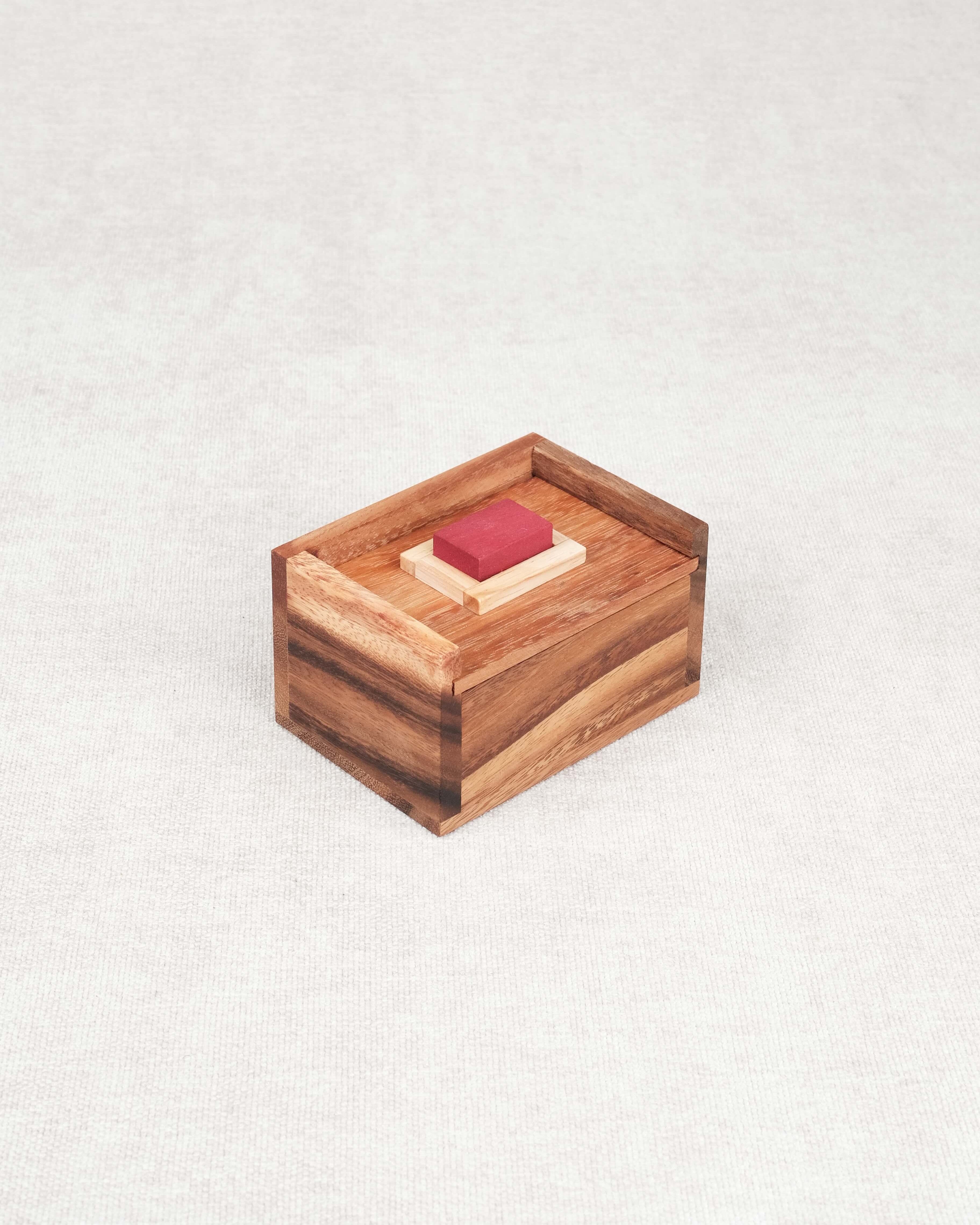 Casse-tête Mission Impossible en bois avec pièce rouge visible dans sa boîte.