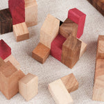 Gros plan sur les pièces colorées du casse-tête La Cité Infernale en bois imbriquées dans la base – Puzzle multi-combinaisons – Jeux Faugère