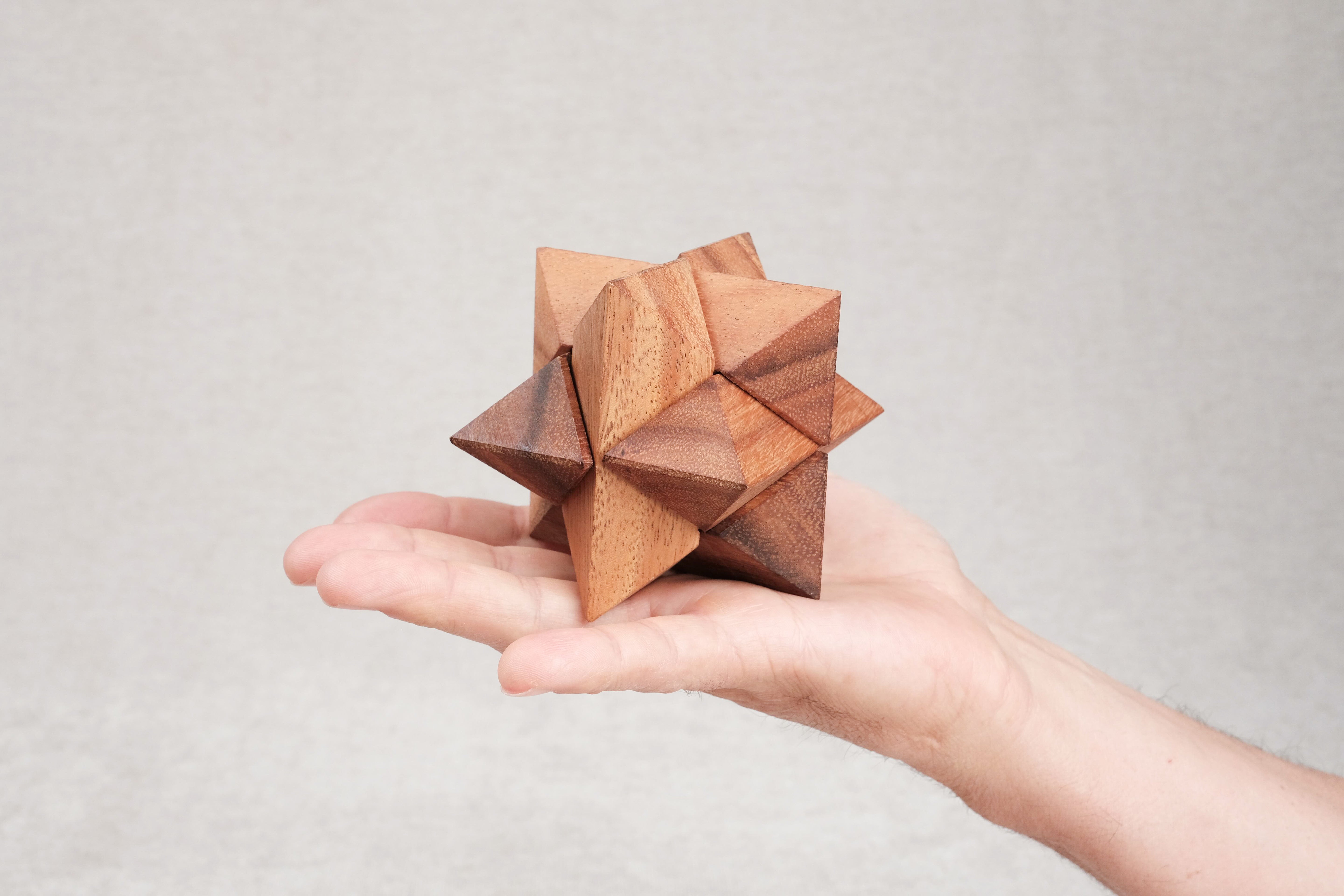 Casse-tête La Star en bois, format 8 cm, tenu dans la main.