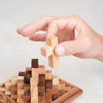 Main retirant une pièce du sommet du casse-tête Grande Kheops pour le démonter.