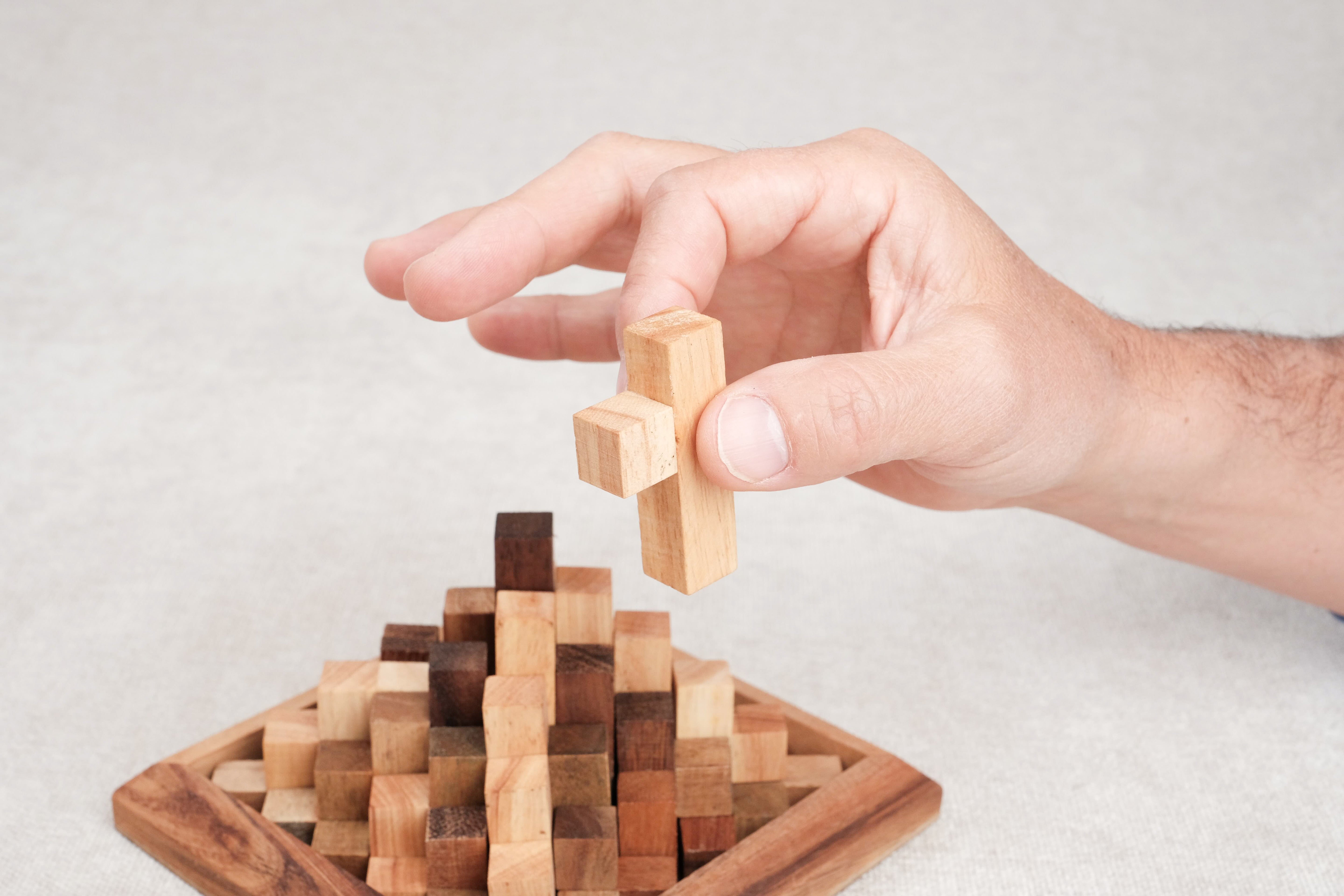 Main retirant une pièce du sommet du casse-tête Grande Kheops pour le démonter.