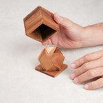 Casse-tête Pyramides en Boîte – manipulation des pièces et de la boîte en bois par une main