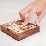 Main en train de déplacer une pièce du taquin