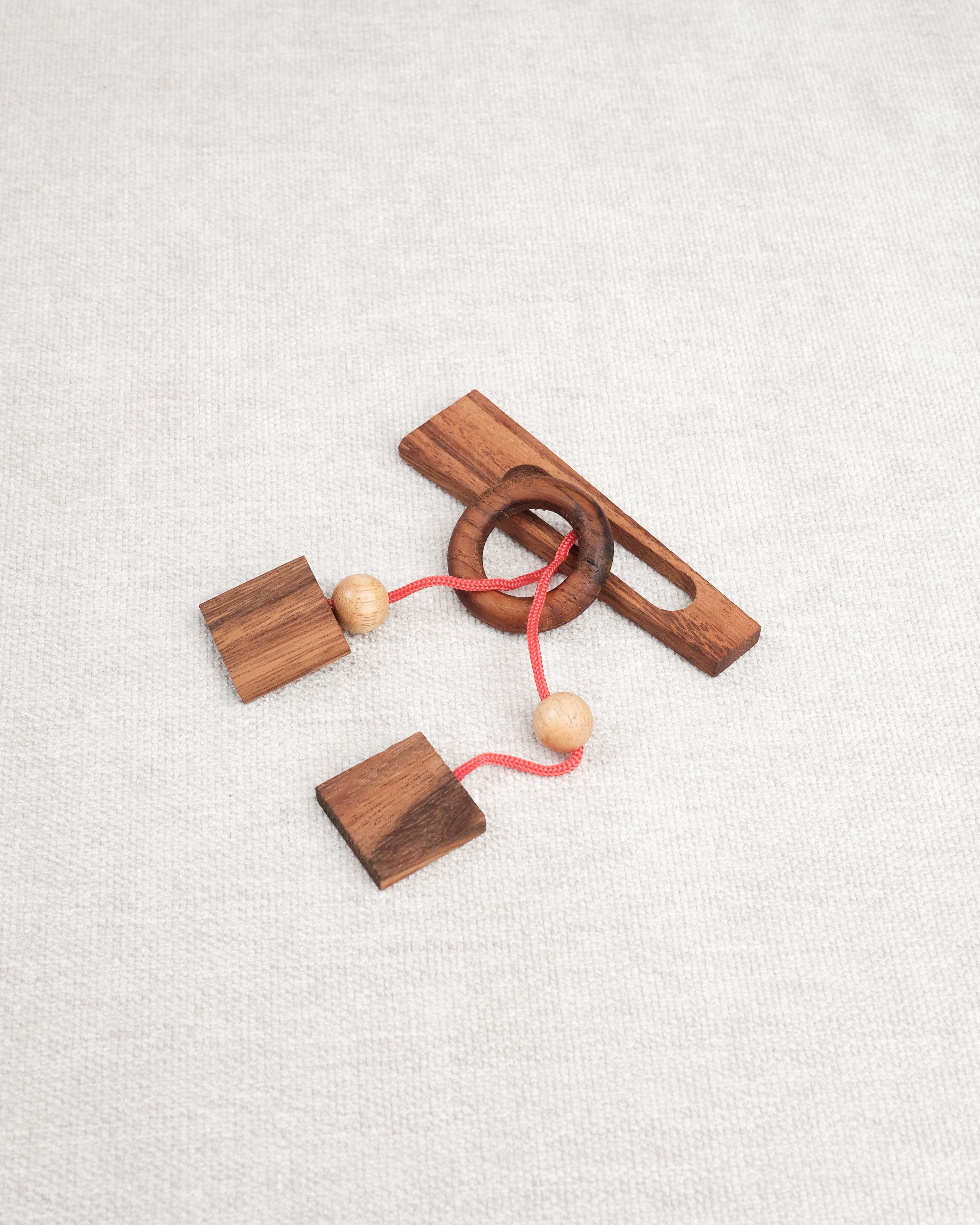 Vue du casse-tête ficelle Diapason en bois avec anneau et cordon rouge – Jeux Faugère