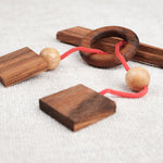 Gros plan sur le mini casse-tête Diapason en bois foncé et boules en hévéa – Jeux Faugère