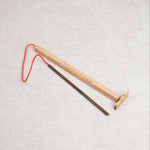 Casse-tête en bois Bozo-Bozo avec baguette et hélice reliée par une ficelle rouge.