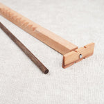 Détail du casse-tête Bozo-Bozo montrant l’hélice en bois et la baguette foncée.