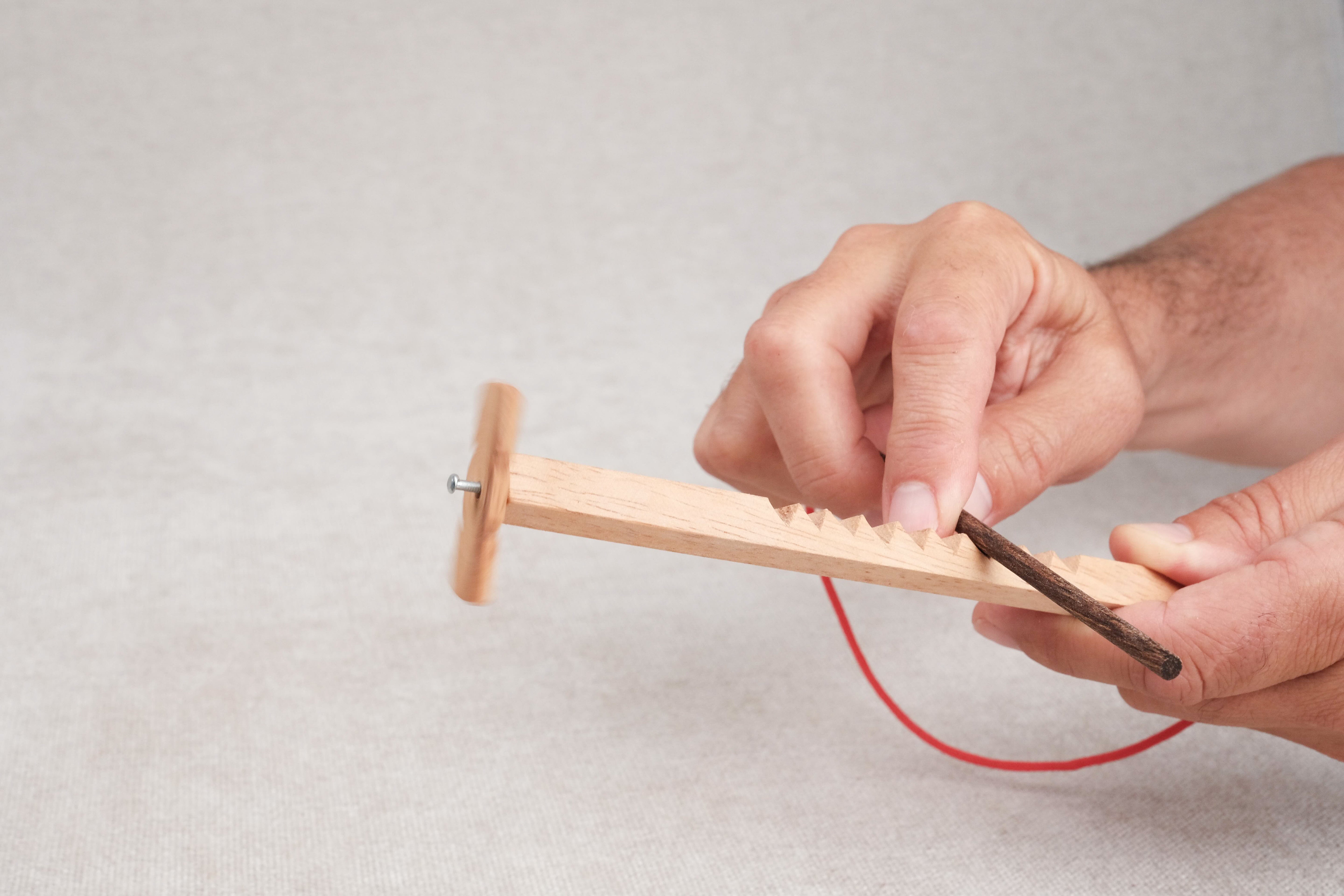 Joueur manipulant le casse-tête Bozo-Bozo pour faire tourner l’hélice.
