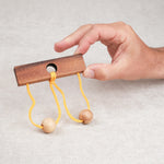 Main tenant le casse-tête ficelle Roméo & Juliette en bois.