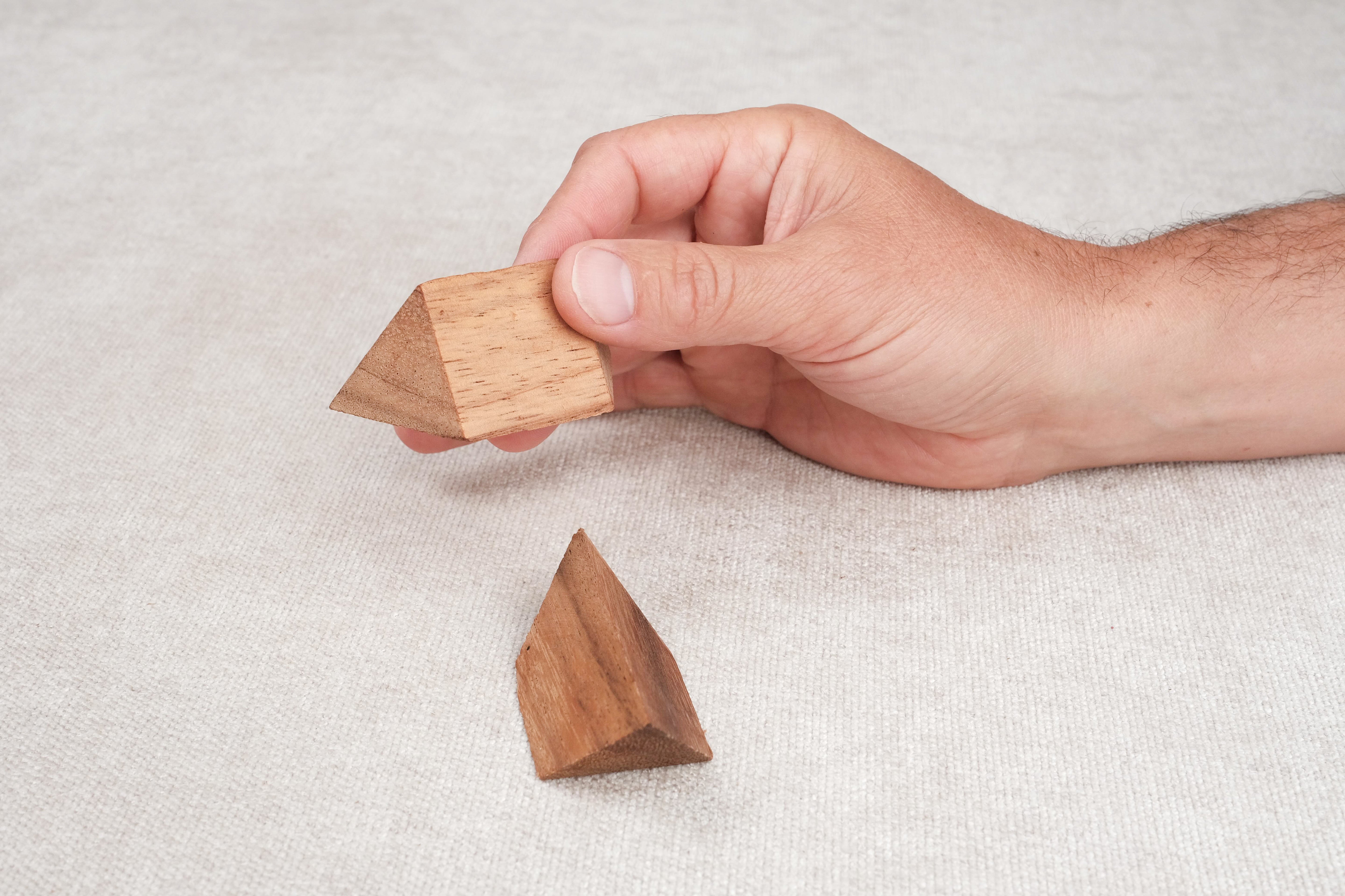 Casse-tête pyramide en bois tenu dans la main – jeu de logique pour enfants dès 4 ans.