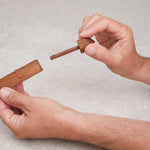 Joueur tenant le casse-tête Bâtonnet du Diable en bois dans les mains.