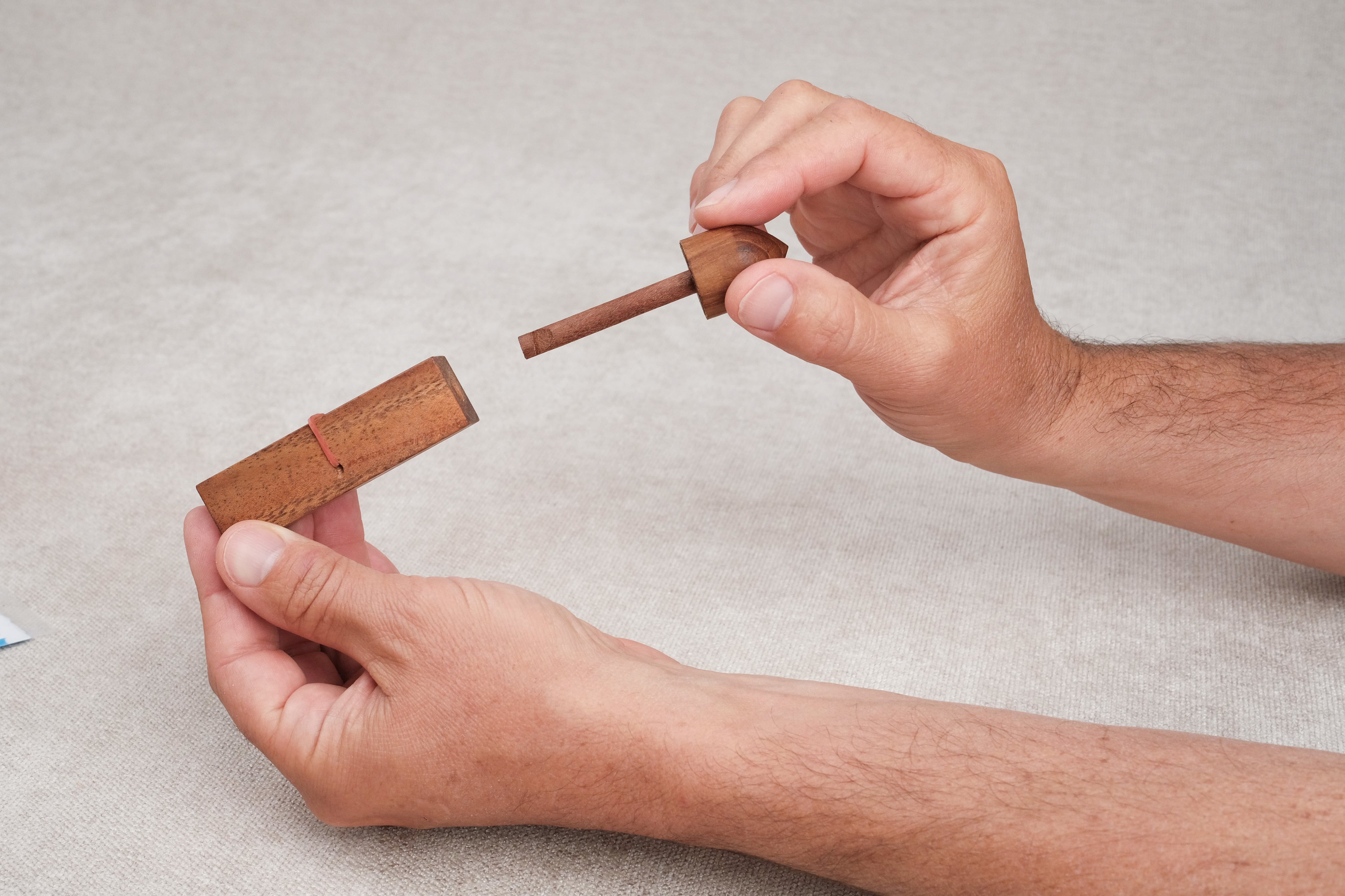 Joueur tenant le casse-tête Bâtonnet du Diable en bois dans les mains.