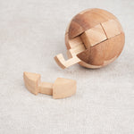 Ballon de foot en bois ouvert avec une pièce retirée, puzzle en cours de démontage.