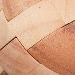 Gros plan sur le ballon de foot en bois montrant le détail des pièces imbriquées.