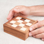 Casse-tête Le Damier en bois – manipulation du coffret par une main