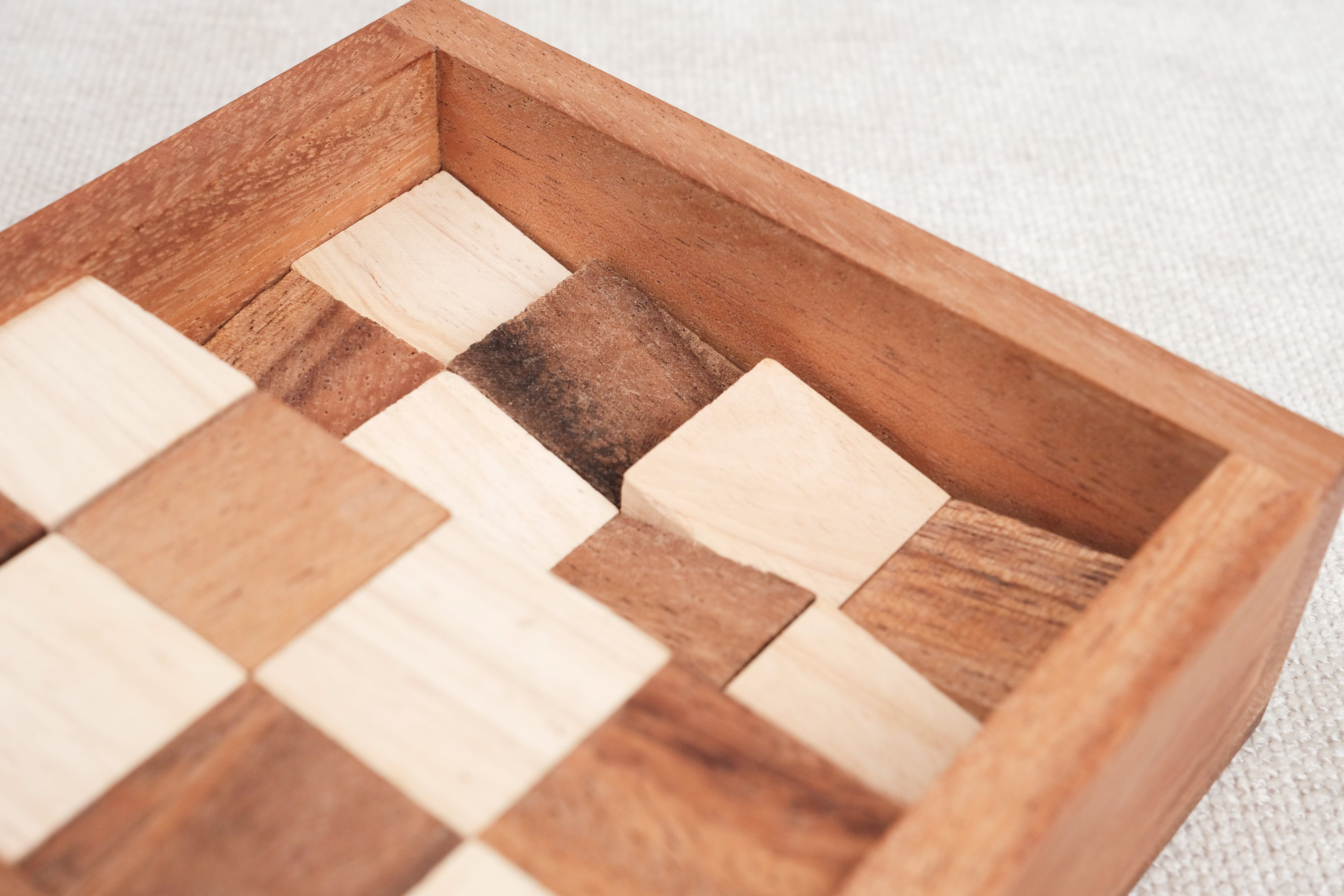 Puzzle en bois Le Damier – pièces cubiques partiellement rangées dans le coffret