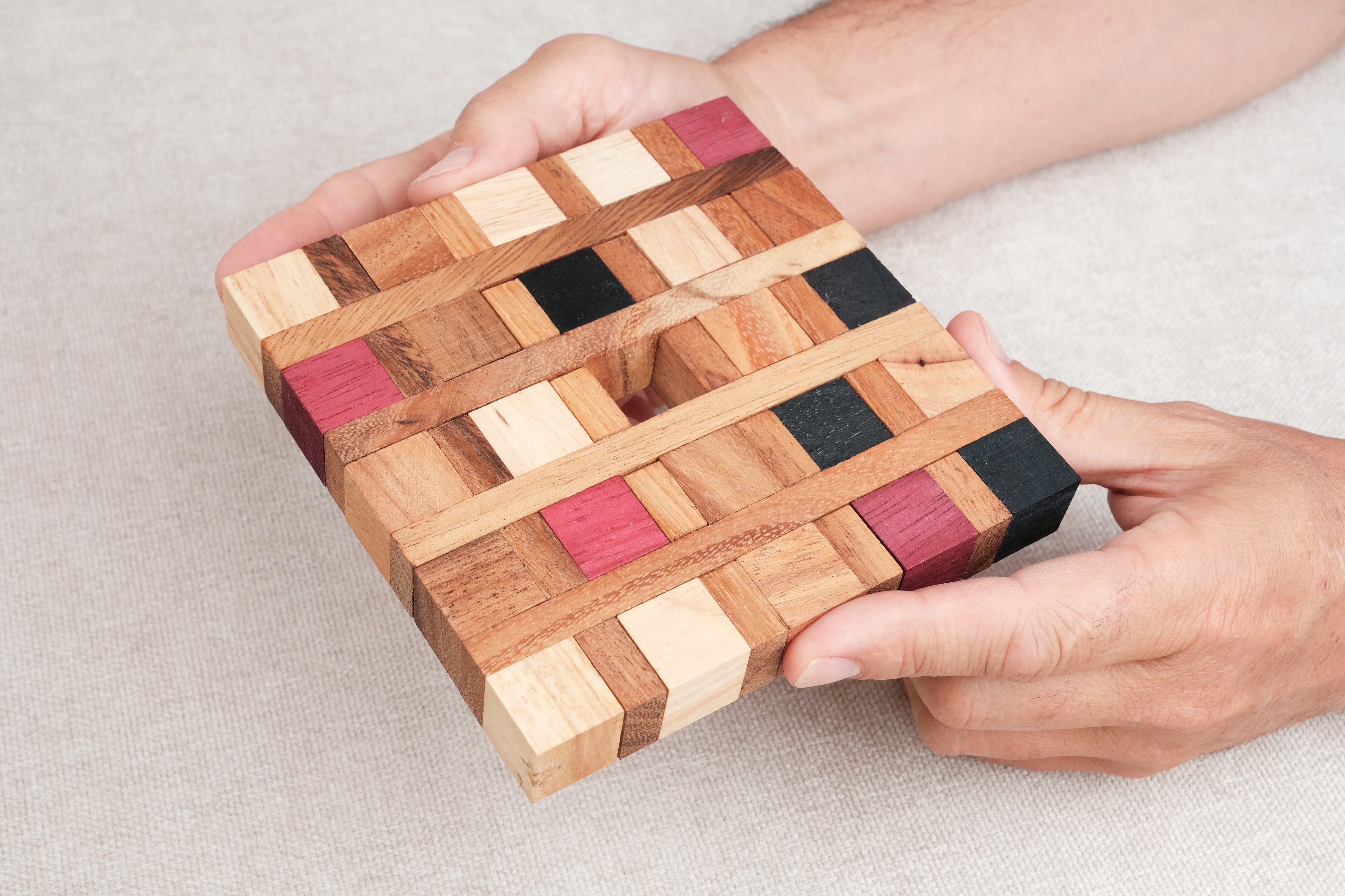 Joueur manipulant le casse-tête Dessous de Plat en bois – Puzzle démonter et remonter Jeux Faugère