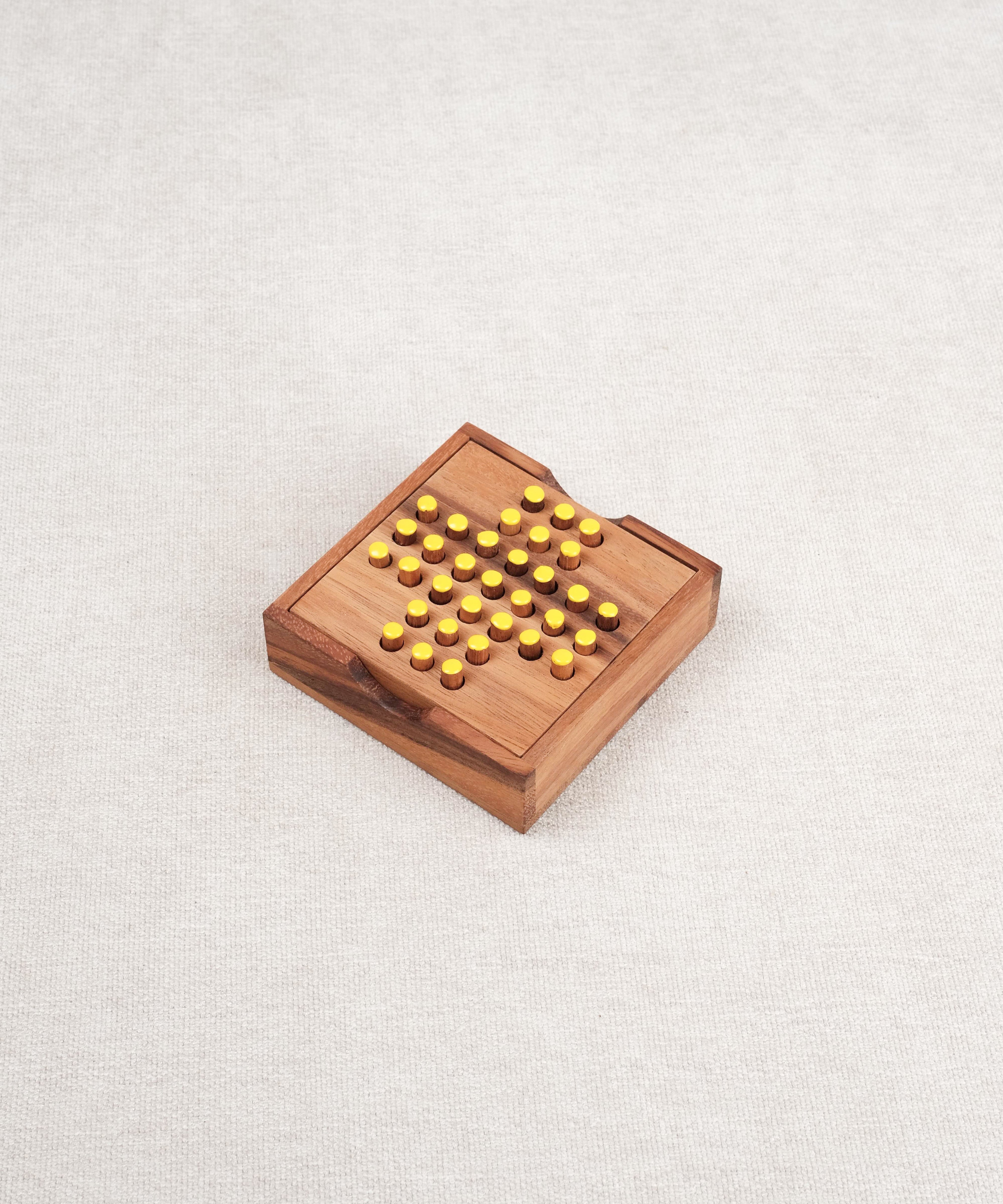 Plateau de solitaire carré en bois avec pions jaunes, vu de dessus