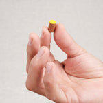 Un pion jaune tenu entre deux doigts