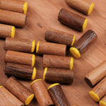 Zoom sur plusieurs pions jaunes en bois dans le coffret