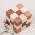 Gros plan du mini cube serpent en bois, motif damier clair et foncé.
