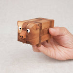 Casse-tête en bois Le Cochon pris dans une main – jouet éducatif à démonter et remonter pour enfants dès 6 ans