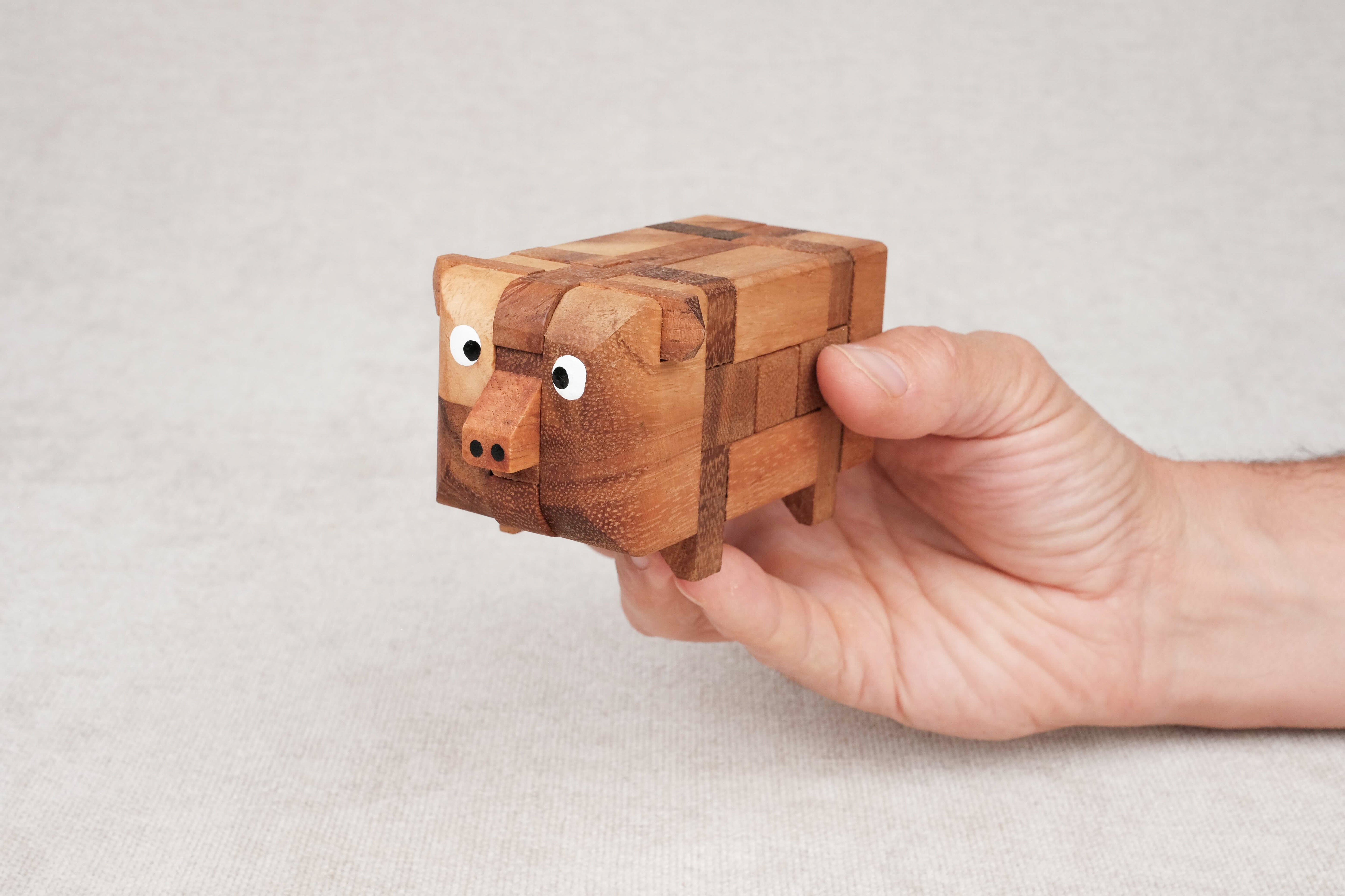 Casse-tête en bois Le Cochon pris dans une main – jouet éducatif à démonter et remonter pour enfants dès 6 ans