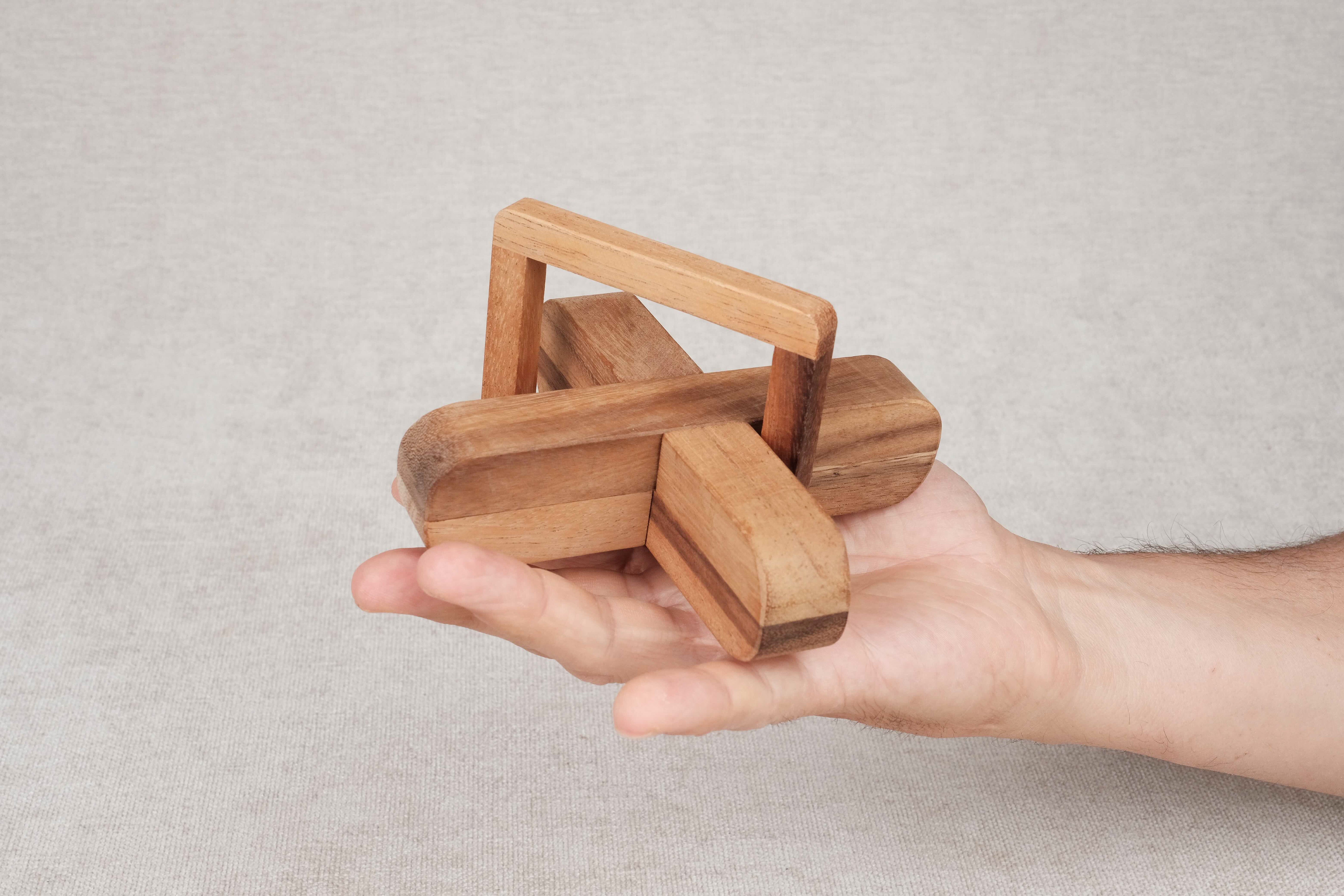 Joueur manipulant le casse-tête en bois L’X – Puzzle à démonter/remonter Jeux Faugère