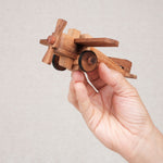 Casse-tête avion en bois à assembler tenu dans une main