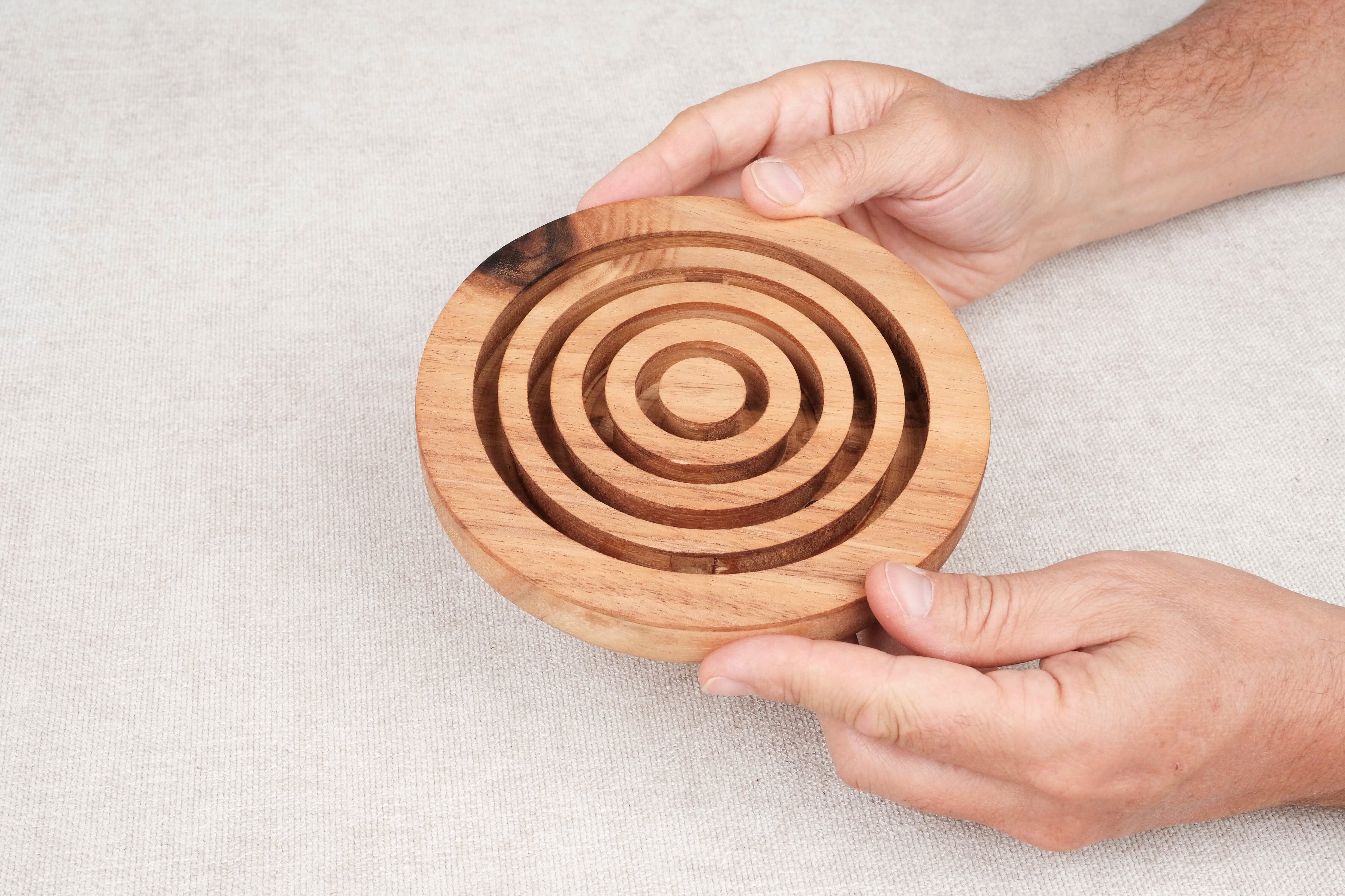 Deux mains tenant le jeu d’adresse Labyrinthe en bois circulaire – Jeux Faugère