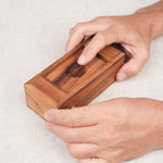 Main en train de d'essayer d'ouvrir la boîte secrète casse-tête en bois