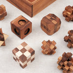 Les 9 casse-têtes sortis du coffret, alignés sur une surface claire