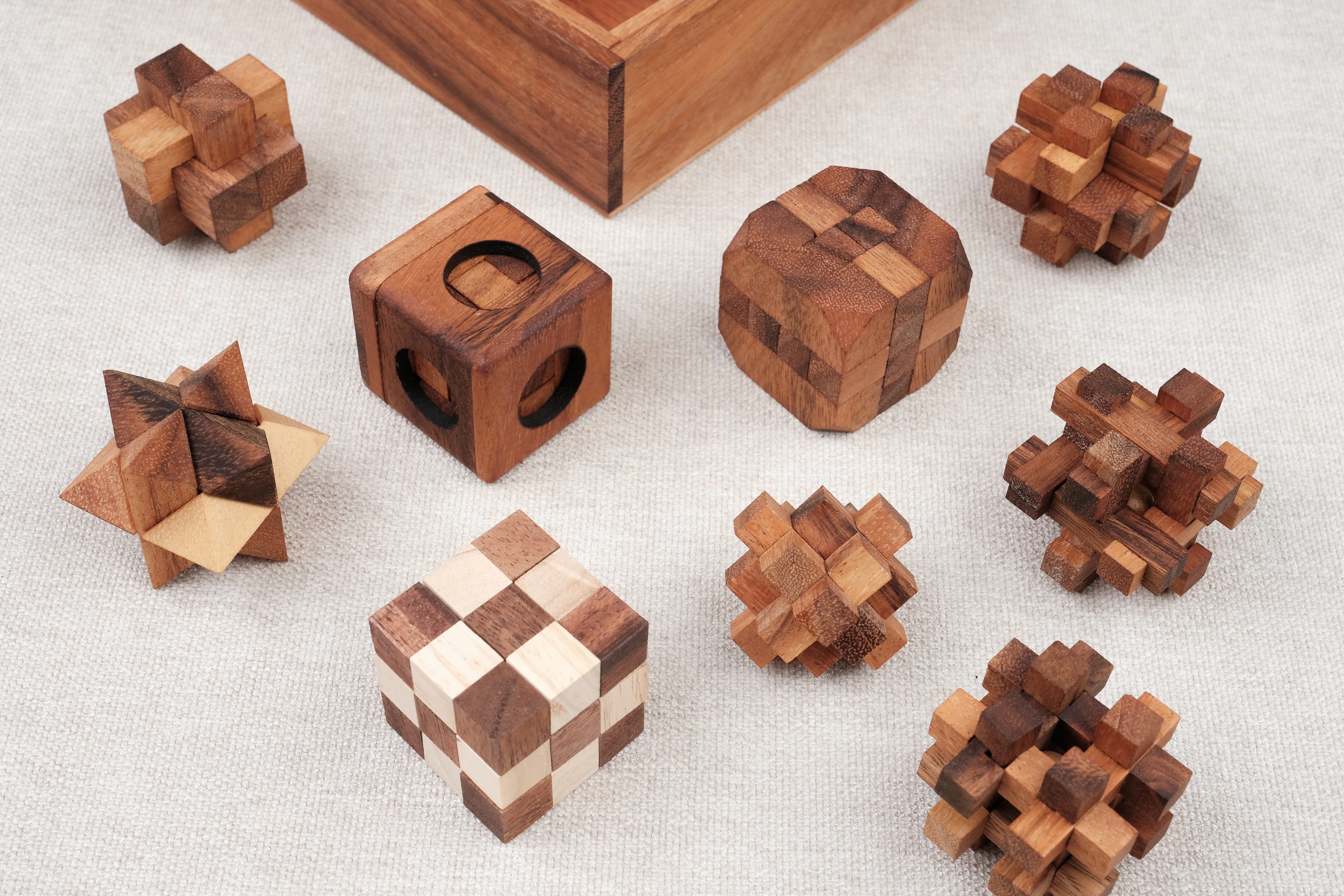 Les 9 casse-têtes sortis du coffret, alignés sur une surface claire