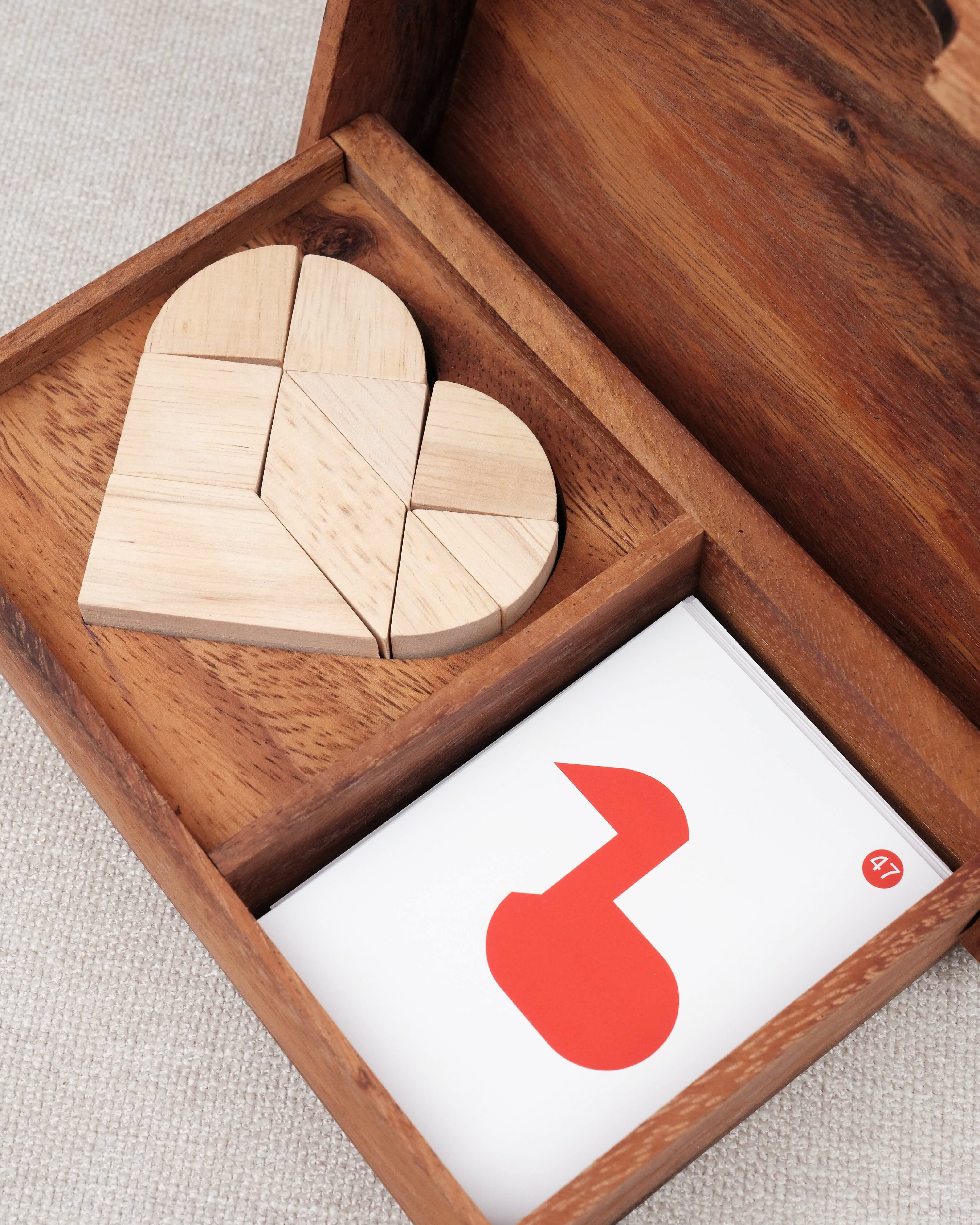 Vue rapprochée du tangram cœur en bois avec cartes – Double Tangram Cœur Jeux Faugère