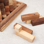 Pièces en bois de la Grande Kheops posées à côté du socle, prêtes à être assemblées.