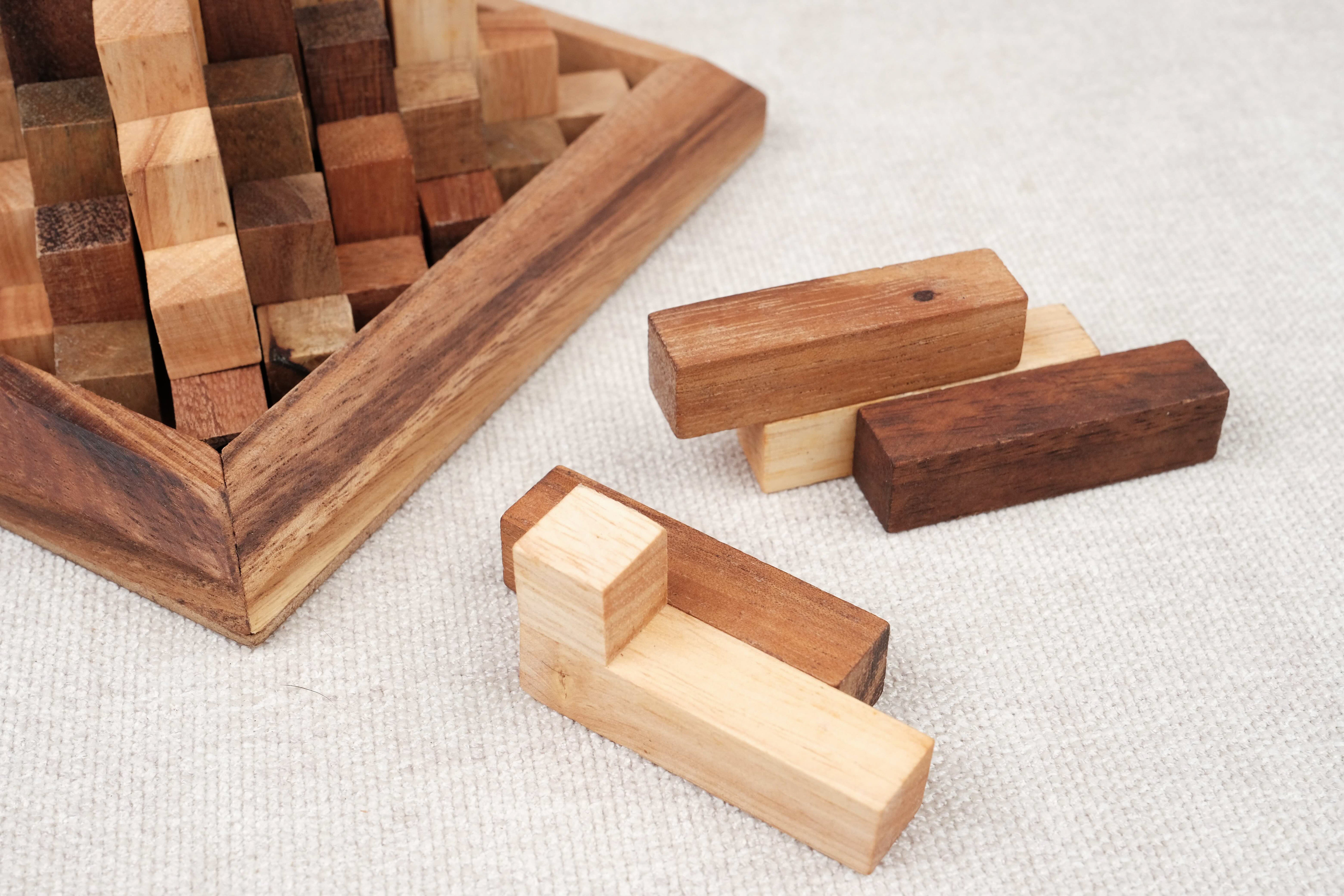 Pièces en bois de la Grande Kheops posées à côté du socle, prêtes à être assemblées.