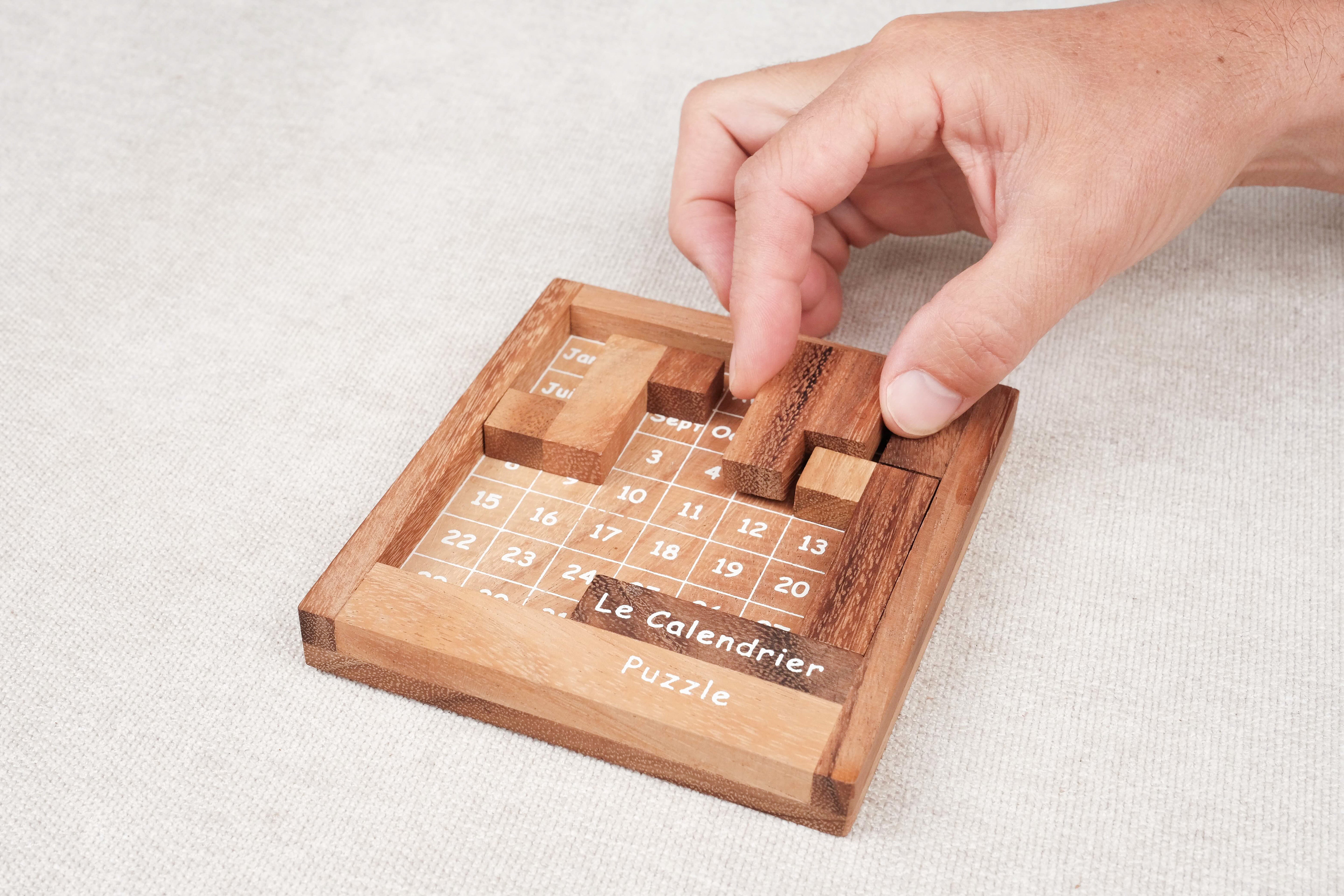 Calendrier puzzle casse-tête en bois avec 365 combinaisons, main en action