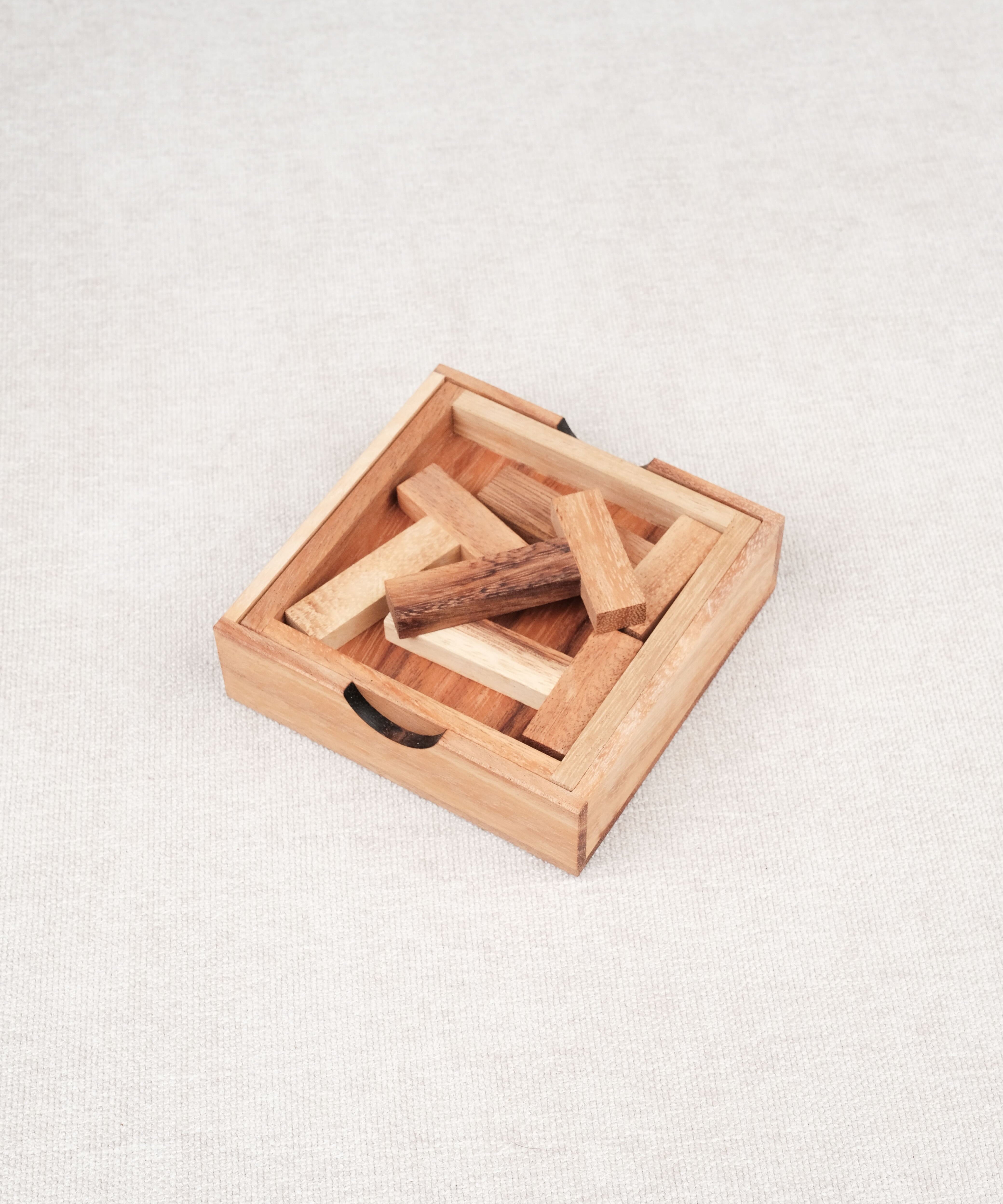 Coffret en bois contenant le casse-tête Les 4 T avec ses pièces rangées